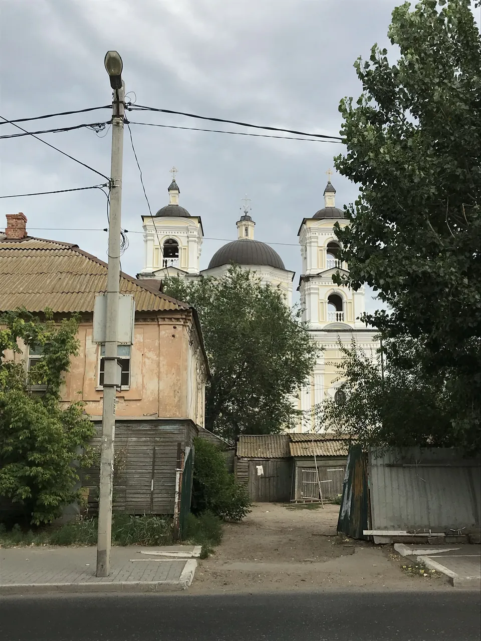 Католический храм Успения Пресвятой Девы Марии: Башни-звонницы и купол храма над старыми домами, 2020 год